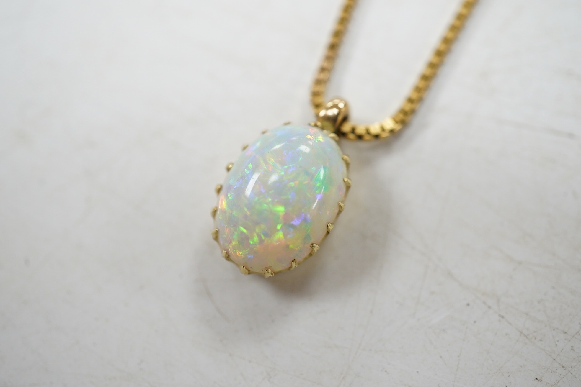 A modern 9kt and single stone oval cabochon white opal set pendant necklace, overall 36cm, gross weight 4.9 grams. Condition - fair to good